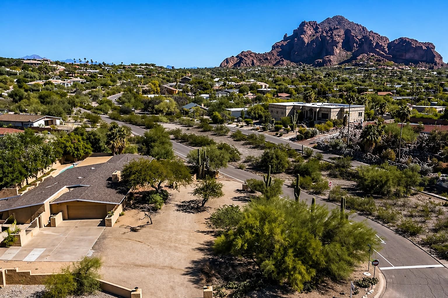 Aerial view of a single-story Paradise Valley home with Camelback Mountain rising behind it.